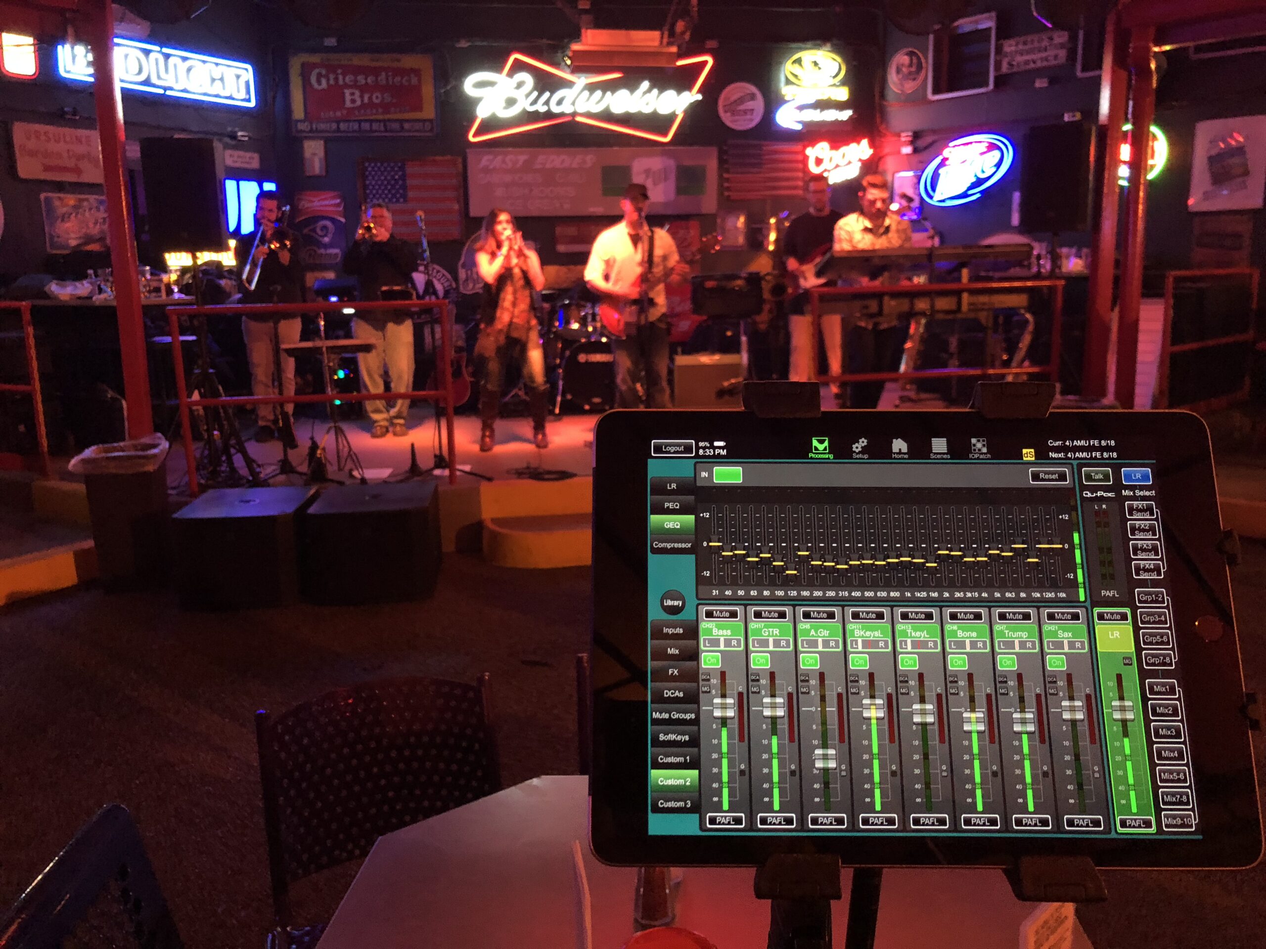 “iPad displaying audio and lighting controls near a concert stage.”