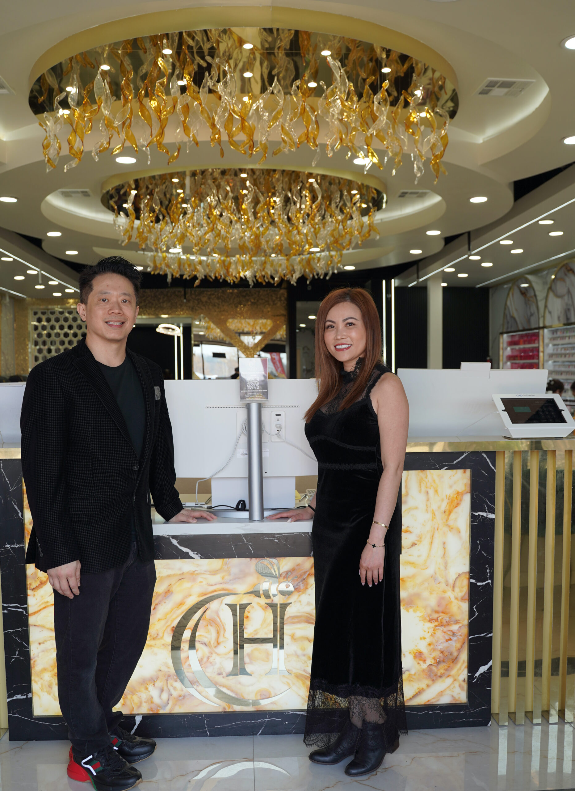 A man and a woman standing at the front desk for the grand opening of their St Louis business.